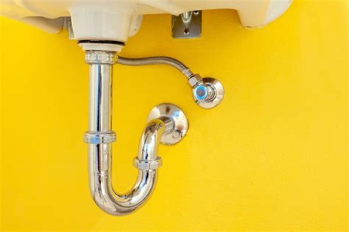 How do you cover exposed pipes under a bathroom sink?