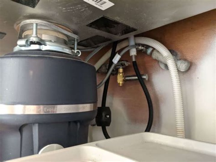 How do you remove a dishwasher hose from a garbage disposal?